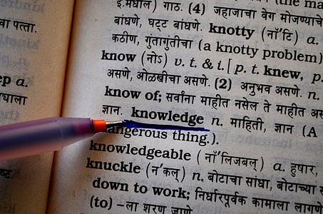 person highlighting knowledge word on book page thumbnail