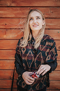 Blonde woman with a can of coke by a wooden wall thumbnail