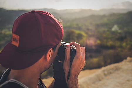 photo of person taking photos on mountain range thumbnail