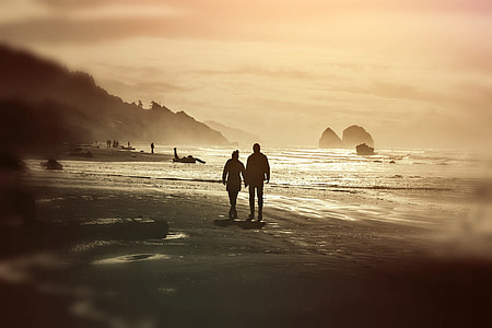 two person walking on beach during daytime thumbnail