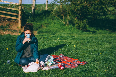 woman sitting on grass holding iPhone 5c thumbnail