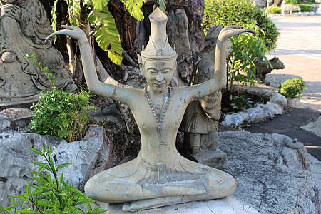 brown concrete statue near green plant thumbnail