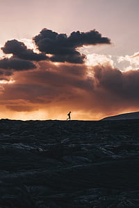 silhouette photography of person walking during sunset thumbnail