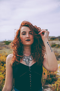 woman wearing black top and silver necklace taking selfie thumbnail