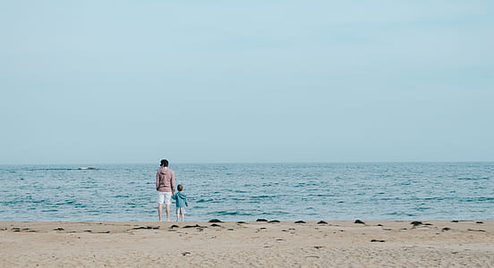 woman holding child on beach at daytime thumbnail