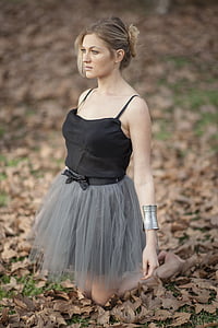 photography of kneeling woman wearing black spaghetti-strap top and green skirt thumbnail