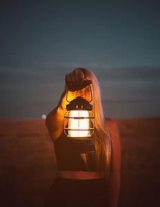 selective focus photo of a woman carrying lighted oil lamp thumbnail