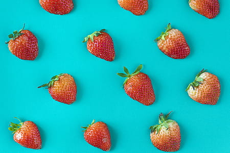 Assorted Sizes of Strawberries on Teal Surface thumbnail