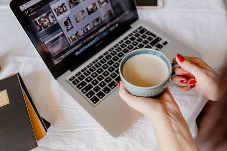 A woman works at a desk with a laptop and a cup of coffee thumbnail
