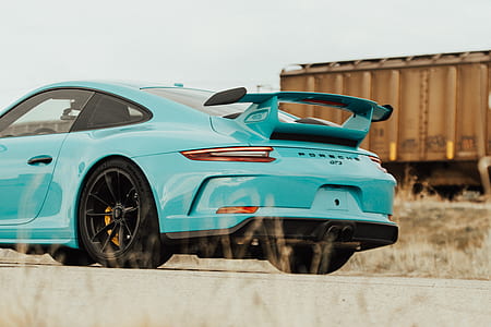 teal Porsche Carrera near railway thumbnail