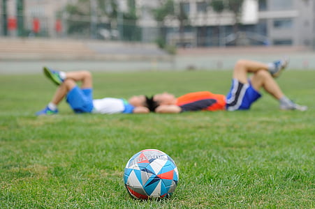 two men lying on the grass near ball thumbnail
