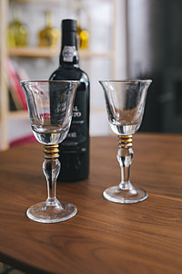 Two empty wine glasses with a bottle of wine on a table thumbnail