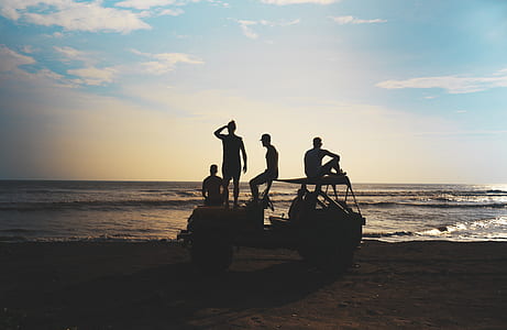 people standing and sitting on vehicle at the beach during day thumbnail