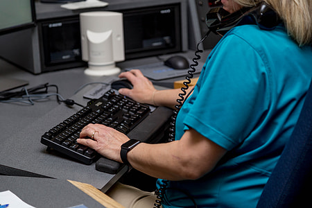 woman typing on her keyboard while listening through phone thumbnail
