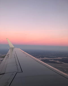 left airplane wing on flight during golden hour thumbnail