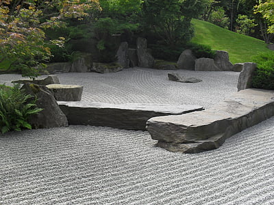 Zen garden with gray stones beside green grass hill thumbnail