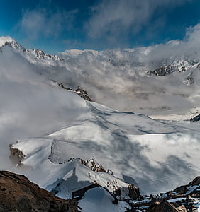 brown mountain covered with snow under blue sky thumbnail