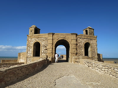 person walking near ruin at daytime thumbnail