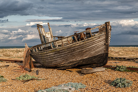 Wide-angle shot of an old abandoned fishing boat and nets. Image captured in Dungeness, Kent, England thumbnail