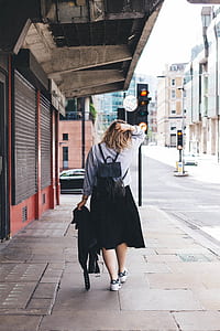 woman walking on the sidewalk during daytime thumbnail