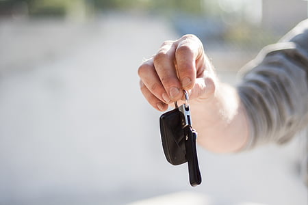 person holding black leather keychain thumbnail