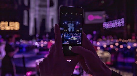 selective focus photography of person taking photo of stage thumbnail
