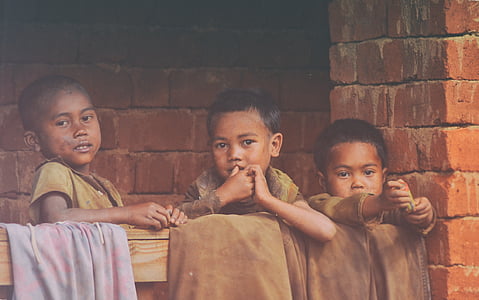 three boys standing behind handrail thumbnail
