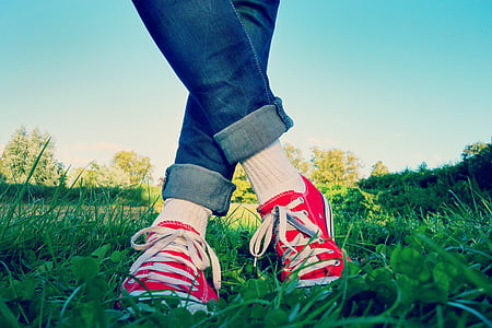 person wearing red sneakers in the grass field thumbnail