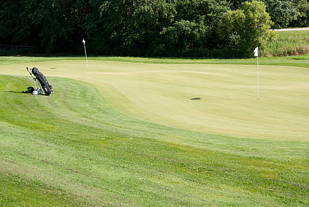 black golf bag placed on golf course thumbnail