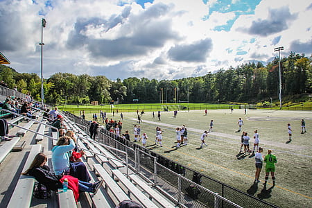 people sitting on bench near a sports stadium thumbnail