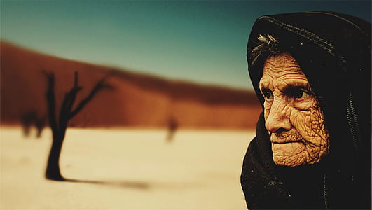 Woman Wearing Black Hijab Behind Bare Tree during Day Time thumbnail