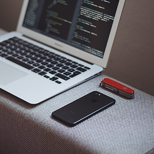 black iPhone 7 beside MacBook Air thumbnail