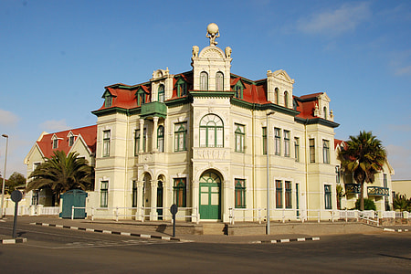 low angle view on white and red concrete building under blue and white clear sky during daytime thumbnail