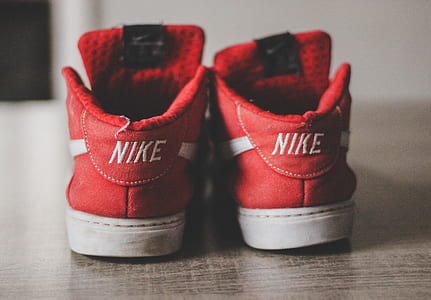 selective focus photography of pair of Nike shoes on floor thumbnail