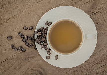 flat lay photography of cup of coffee with coffee beans thumbnail