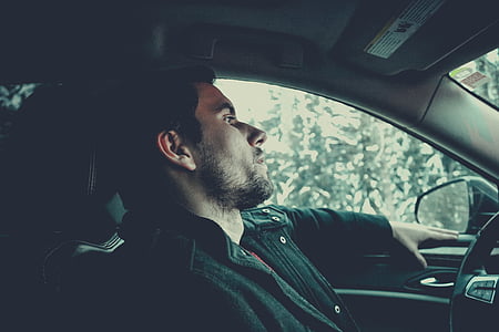man in black jacket on car during daytime thumbnail