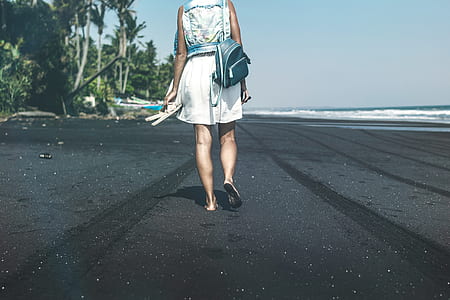 Young woman on a black sand beach, Bali island. thumbnail