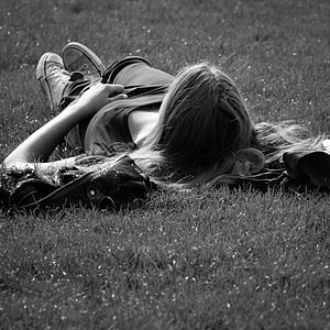 grayscale photo of woman lying on grass thumbnail