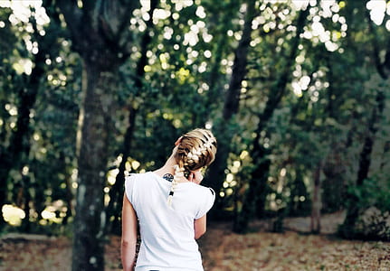 woman in white shirt standing on forest during daytime thumbnail
