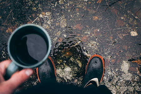 person standing and holding gray ceramic mug with coffee thumbnail
