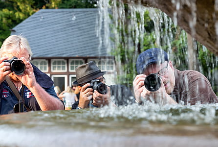 three men holding black DSLR cameras thumbnail