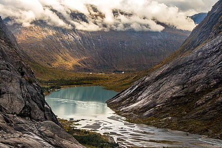 river between mountain under white clouds during daytime thumbnail