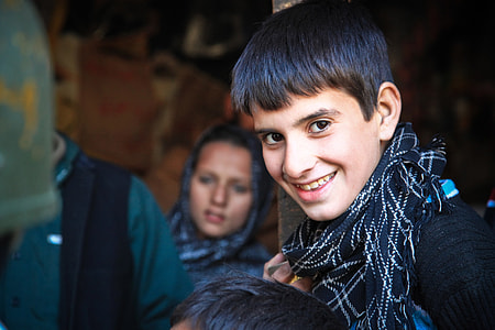 boy smiling beside woman leaning on wall thumbnail