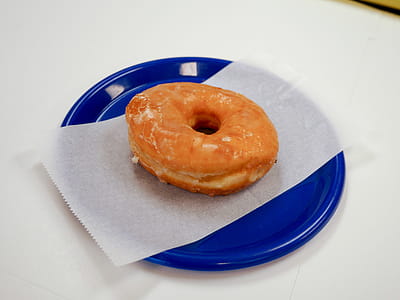 Glazed donut sitting on a blue plate thumbnail