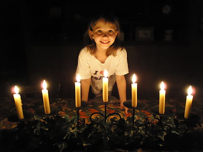 girl standing in front of lit candles thumbnail