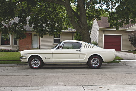 white coupe parked near gray house thumbnail