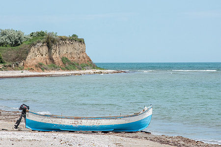 blue and white kayak near beach at daytime thumbnail