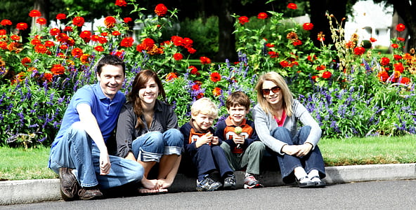 family sitting on road beside red poppy flowerss thumbnail