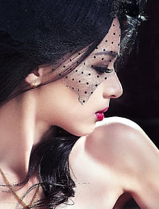 woman in red lipstick and black polka-dot mesh headdress thumbnail