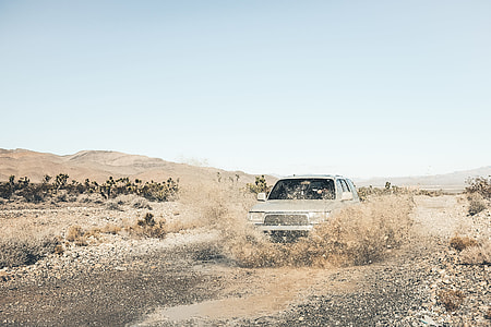 gray car at the rural road splashes a water under blue sky at daytime thumbnail